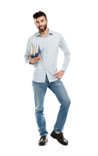 Junger bärtiger lächelnder Mann mit Büchern in der Hand auf weißem Grund — Stockfoto