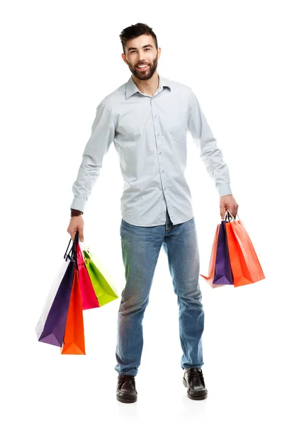 Bonito homem segurando sacos de compras — Fotografia de Stock