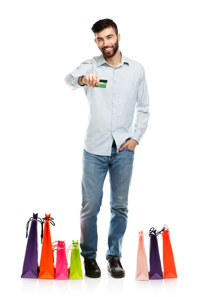 Handsome man with shopping bags and holding credit card — Stock Photo, Image