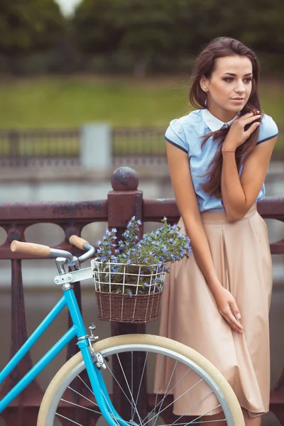 Giovane donna bella, elegantemente vestita con bicicletta — Foto Stock