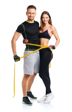 Happy athletic couple - man and woman with measuring tape on the clipart
