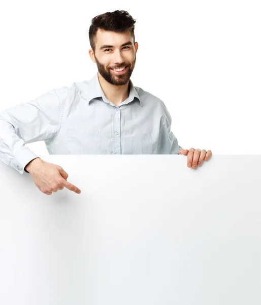 Un jeune homme barbu montrant un panneau vierge, isolé au-dessus du blanc — Photo