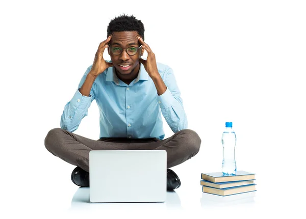 Africano americano estudiante universitario con dolor de cabeza sentado en blanco —  Fotos de Stock