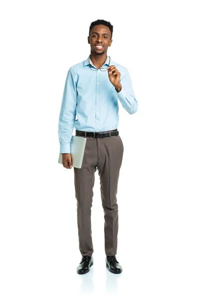 Happy african american college student standing with laptop on w — Stock Photo, Image