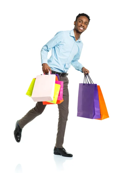 Homem americano africano feliz segurando sacos de compras no backgr branco — Fotografia de Stock