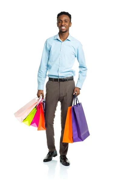 Homem americano africano feliz segurando sacos de compras no backgr branco — Fotografia de Stock