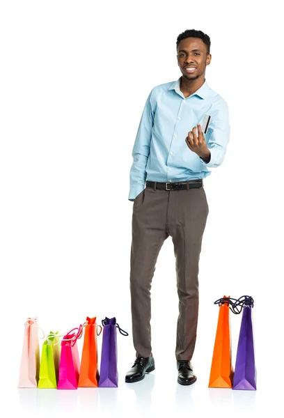 Happy african american man with shopping bags  and holding credi — Stock Photo, Image