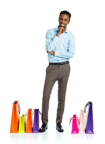 Homem americano africano feliz com sacos de compras no backgroun branco — Fotografia de Stock