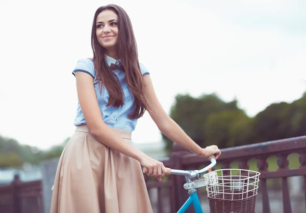 Young beautiful, elegantly dressed woman with bicycle in the par — Stock Photo, Image