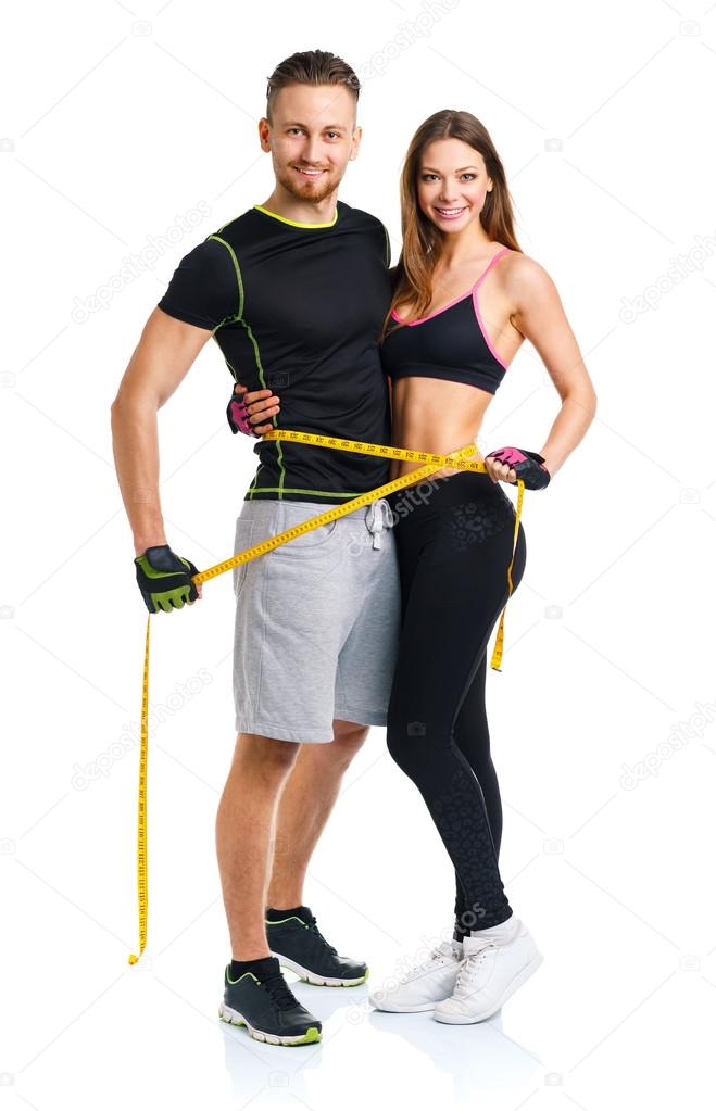 Happy athletic couple - man and woman with measuring tape on the