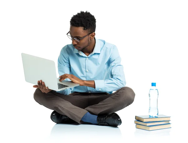 Studente universitario afroamericano seduto con laptop su bianco — Foto Stock