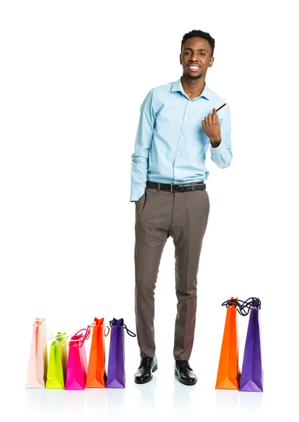 Homem americano africano feliz com sacos de compras e segurando crédito — Fotografia de Stock