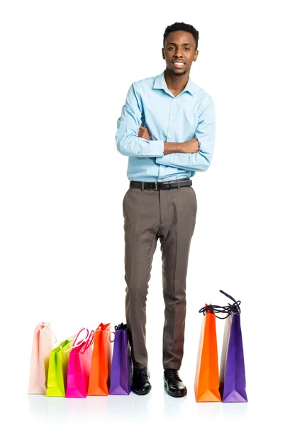 Homem americano africano feliz com sacos de compras no backgroun branco — Fotografia de Stock