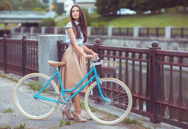 Young beautiful, elegantly dressed woman with bicycle — Stock Photo, Image