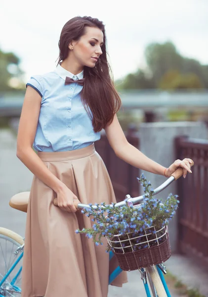 Jonge mooie, elegant gekleed vrouw met fiets — Stockfoto