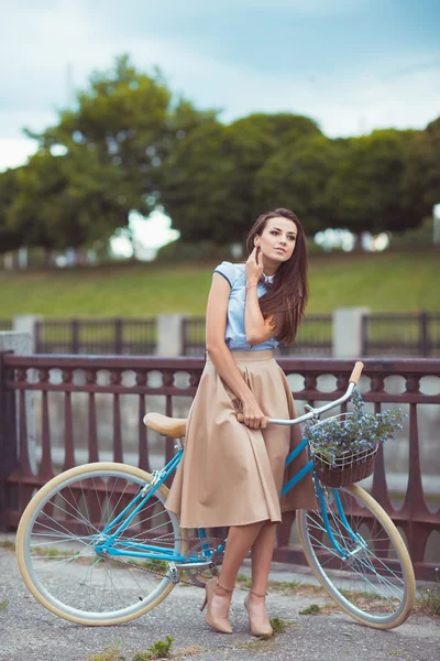 Joven mujer hermosa, elegantemente vestida con bicicleta — Foto de Stock