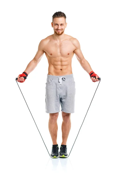 Athletic attractive man jumping on a rope on the white — Stock Photo, Image