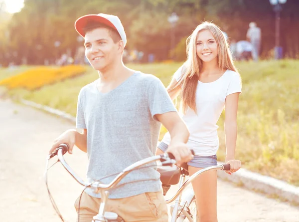 Jonge man en vrouw een fiets in de buitenlucht park — Stockfoto