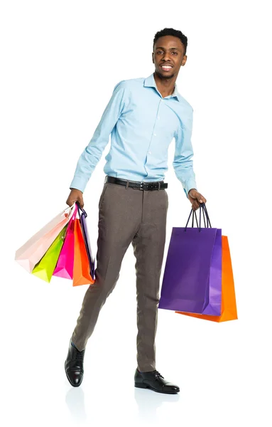 Homem americano africano feliz segurando sacos de compras no backgr branco — Fotografia de Stock