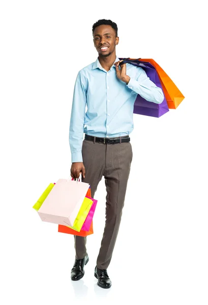 Feliz afroamericano hombre sosteniendo bolsas de compras en blanco backgr —  Fotos de Stock