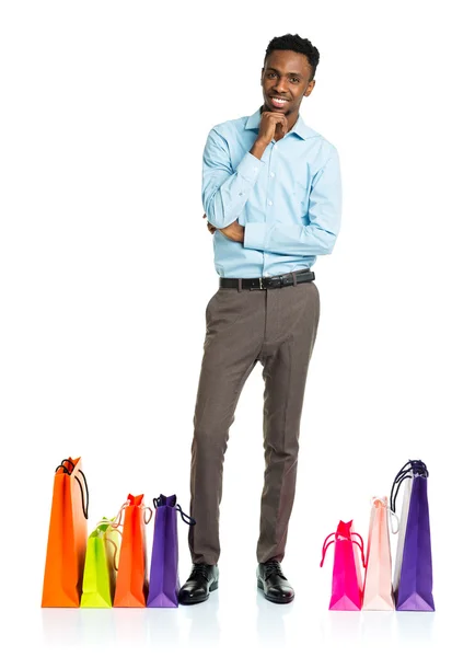 Happy african american man with shopping bags on white backgroun — Stock Photo, Image