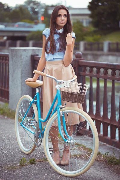 Joven mujer hermosa, elegantemente vestida con bicicleta — Foto de Stock