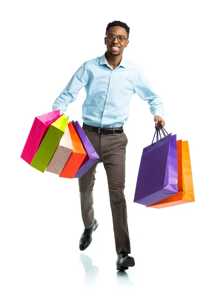 Homem americano africano feliz segurando sacos de compras no backgr branco — Fotografia de Stock