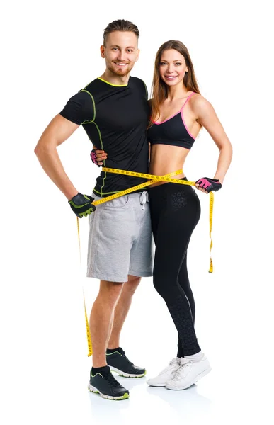 Happy athletic couple - man and woman with measuring tape on the — Stock Photo, Image