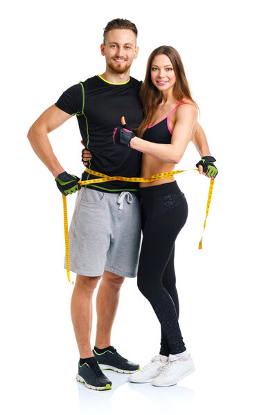 Happy athletic couple - man and woman with measuring tape on and
