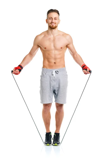 Athletic attractive man jumping on a rope on the white — Stock Photo, Image
