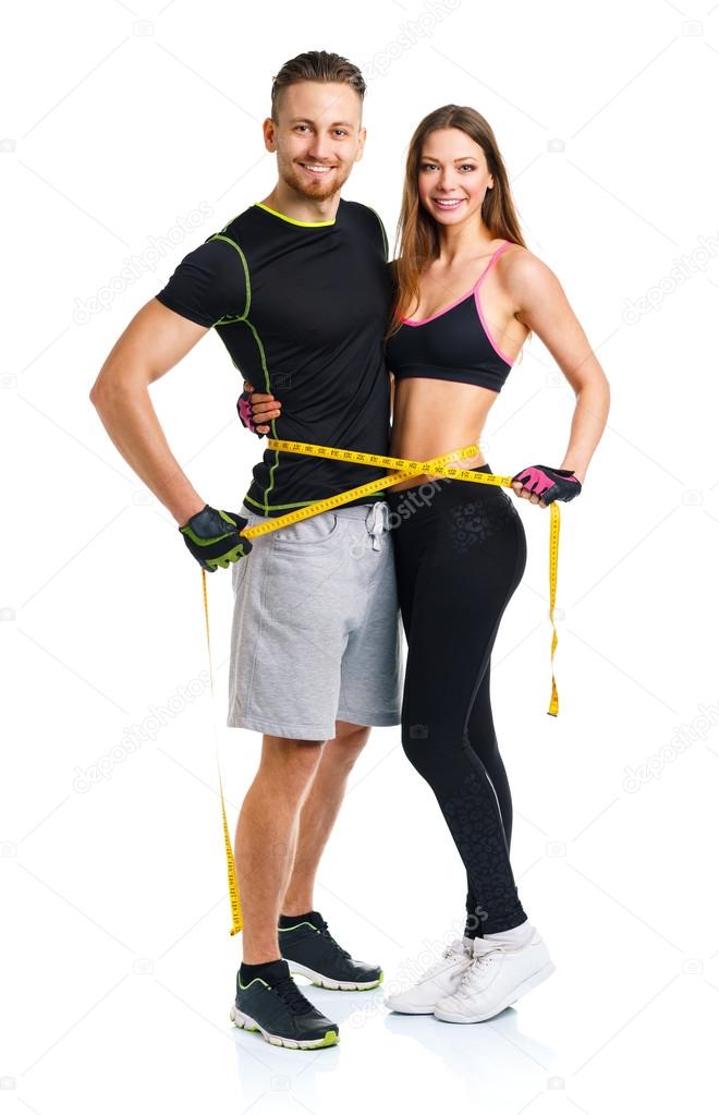 Happy athletic couple - man and woman with measuring tape on the