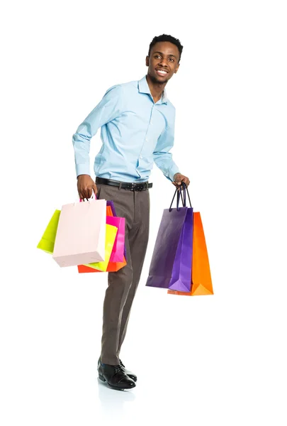 Happy african american man with shopping bags on white — Stock Photo, Image