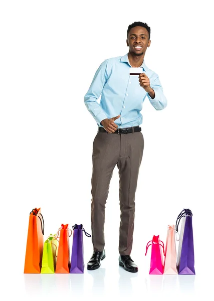 Homem americano africano feliz com sacos de compras e segurando crédito — Fotografia de Stock