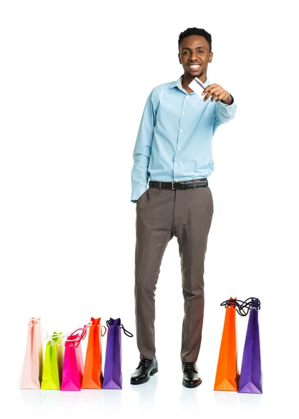 Homem americano africano feliz com sacos de compras e segurando crédito — Fotografia de Stock