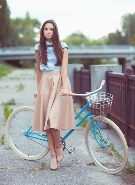 Joven mujer hermosa, elegantemente vestida con bicicleta — Foto de Stock