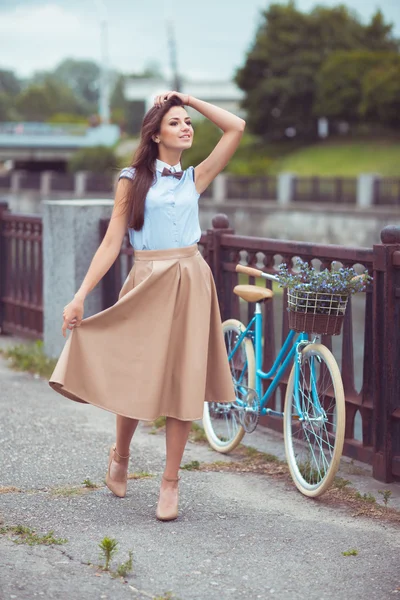 Joven mujer hermosa, elegantemente vestida con bicicleta al aire libre — Foto de Stock