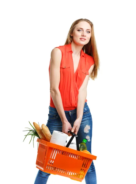 Mujer joven feliz sosteniendo una cesta llena de comida saludable en blanco —  Fotos de Stock
