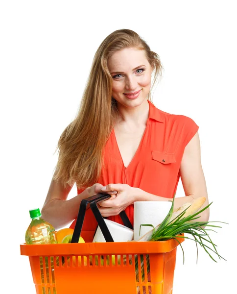 Glad ung kvinna med en korg full av hälsosam mat på vit — Stockfoto