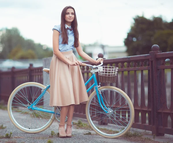 Joven mujer hermosa, elegantemente vestida con bicicleta — Foto de Stock