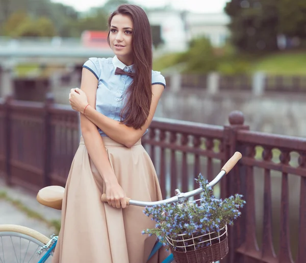 Joven mujer hermosa, elegantemente vestida con bicicleta — Foto de Stock