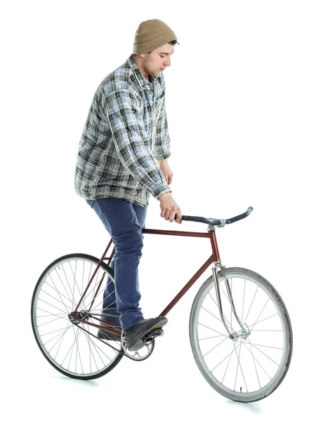 Jovem fazendo truques em bicicleta de engrenagem fixa em um branco — Fotografia de Stock