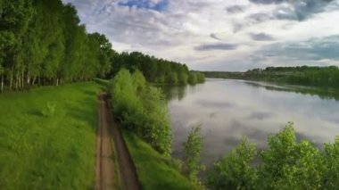 Toprak yol ve sakin göl üzerinde uçan