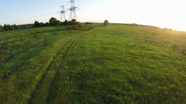 Bei Sonnenuntergang über Stromleitung fliegen — Stockvideo