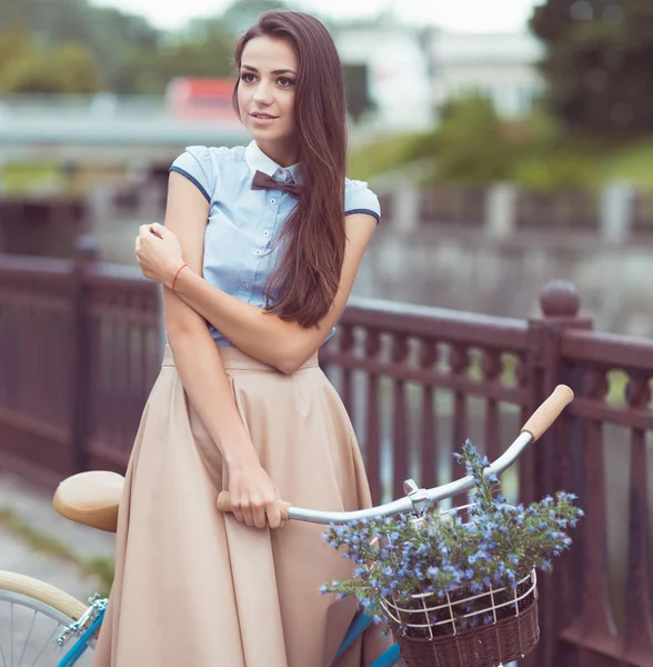 Joven mujer hermosa, elegantemente vestida con bicicleta — Foto de Stock