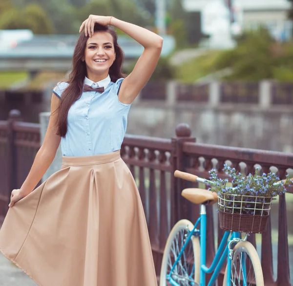 Joven mujer hermosa, elegantemente vestida con bicicleta — Foto de Stock