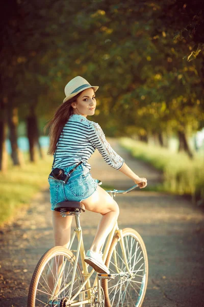 Belle jeune femme dans un chapeau en vélo à l'extérieur. Actif — Photo