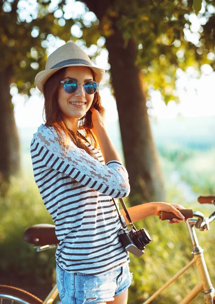 야외에서 자전거를 타고 모자 사랑 스러운 젊은 여자. 활성 pe — 스톡 사진
