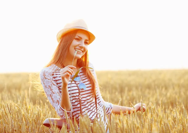 Lovely young woman stands in a field with her bicycle — Stock Photo, Image