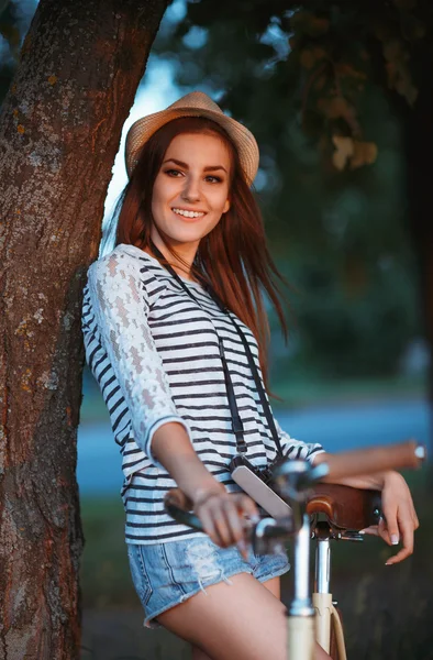 Piękne Młoda kobieta w kapeluszu z rowerem na zewnątrz — Zdjęcie stockowe