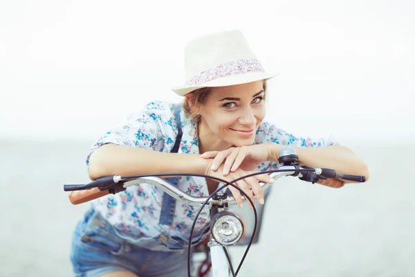 Vacker kvinna med cykel på stranden — Stockfoto